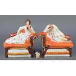 A pair of Staffordshire figures reclining on couches reading books and holding instruments 6 1/2"