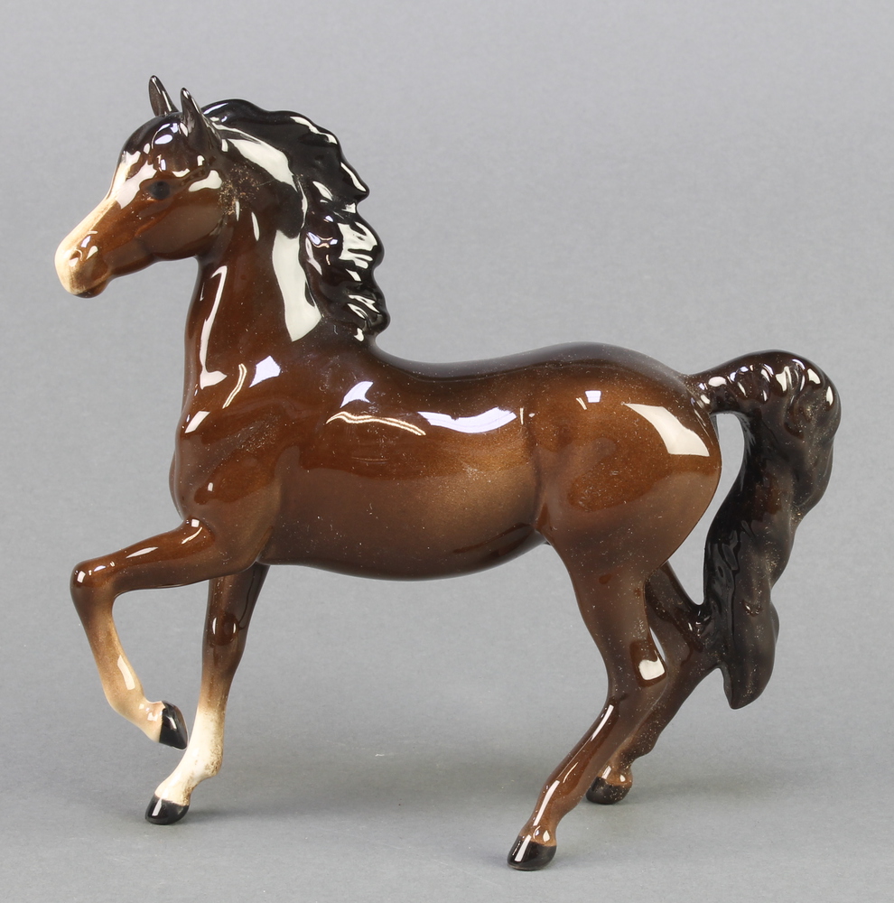 A Beswick figure of a standing pony, front leg raised, 7"