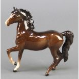 A Beswick figure of a standing pony, front leg raised, 7"