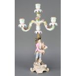 A Meissen candlestick, the 3 light upper section encrusted with flowers the base with a gentleman