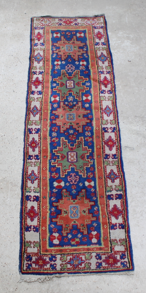 A blue ground Caucasian runner with 5 stylised medallions to the centre within multi row borders 94"