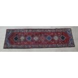 A red and blue ground Persian Yalameh runner 118" x 34"There is heavy wear to one end of the rug and