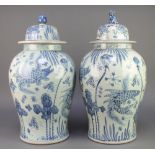 A pair of Chinese blue and white baluster jars and covers decorated with carp amongst seaweed 23"