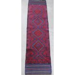 A red and blue ground Meshwani runner with 4 diamonds to the centre 99" x 23 1/2"