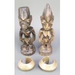 A pair of Ebeji carved wooden figures 11" together with a pair of African money bangles