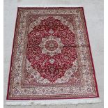 A red and gold patterned Keshan style Belgian cotton rug with central medallion 76" x 52"