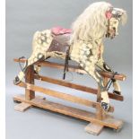 A dappled grey rocking horse with real hair mane and tail on a wooden frame base 50"h x 53"l x 18"