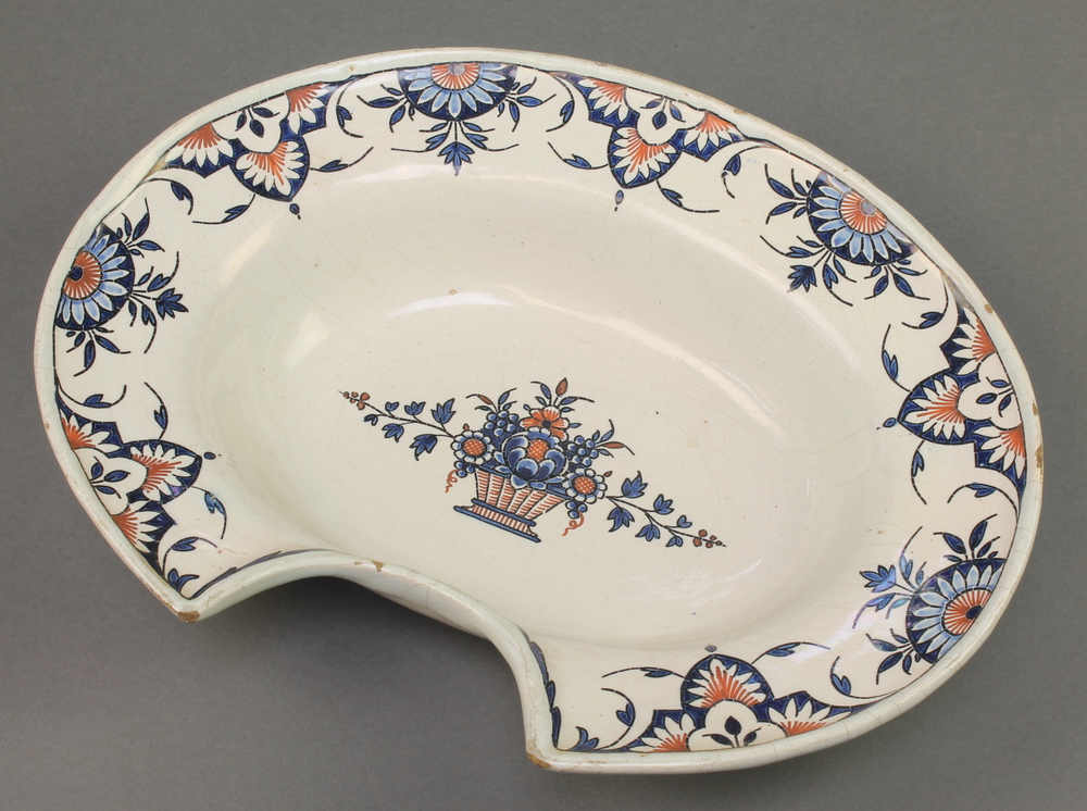 A 19th Century Delft shaving bowl with stylised floral motifs surrounding a basket of flowers 14"