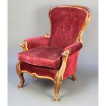 A Victorian mahogany show frame armchair upholstered in red buttoned material raised on carved