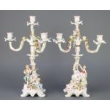 A pair of Potschappel 4 light candelabra encrusted with flowers, the base with lady and gentleman