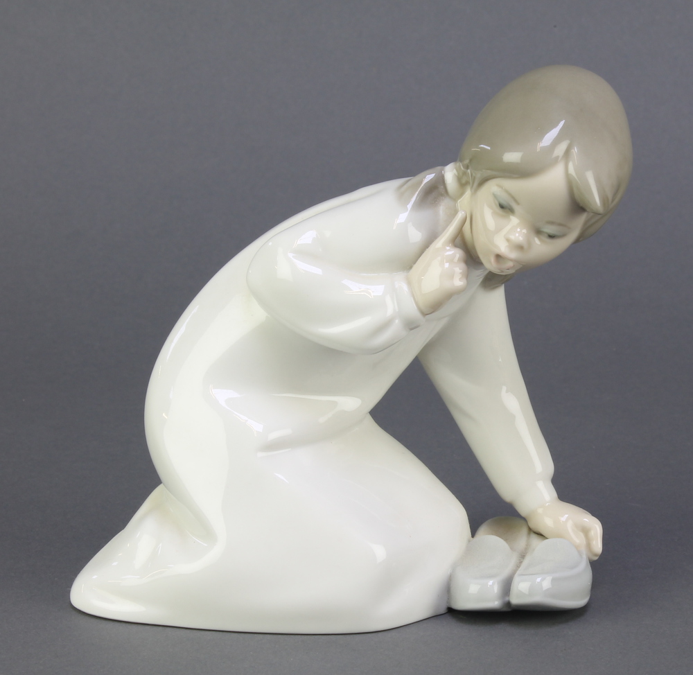 A Lladro figure of a kneeling girl with slippers 8" This lot is in good condition.