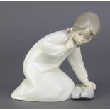 A Lladro figure of a kneeling girl with slippers 8" This lot is in good condition.