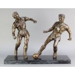 A bronzed figure group of 2 footballers raised on a rectangular black veined marble base 19"h x 24