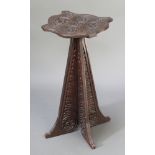 A Continental Art Nouveau oak shaped and carved occasional table raised on waisted panel supports