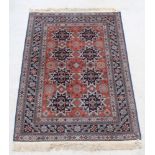 A Caucasian style brown and blue ground rug with 8 stylised medallions to the centre within multi