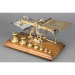 A pair of 19th Century brass letter scales raised on a mahogany stand with 7 weights - 1lb, 8 ozs, 4