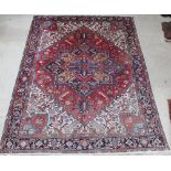 A Persian red, blue and white ground Heriz carpet with stylised diamond to the centre 142" x 109"