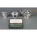 A silver plated 3 piece tea set and a cased pair of servers