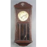 A 1930's 8 day striking wall clock with silvered dial contained in an oak case