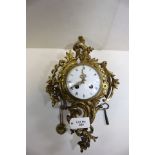 A 19TH CENTURY FRENCH GILT BRASS CARTEL CLOCK, the circular white enamel dial supporting a twin