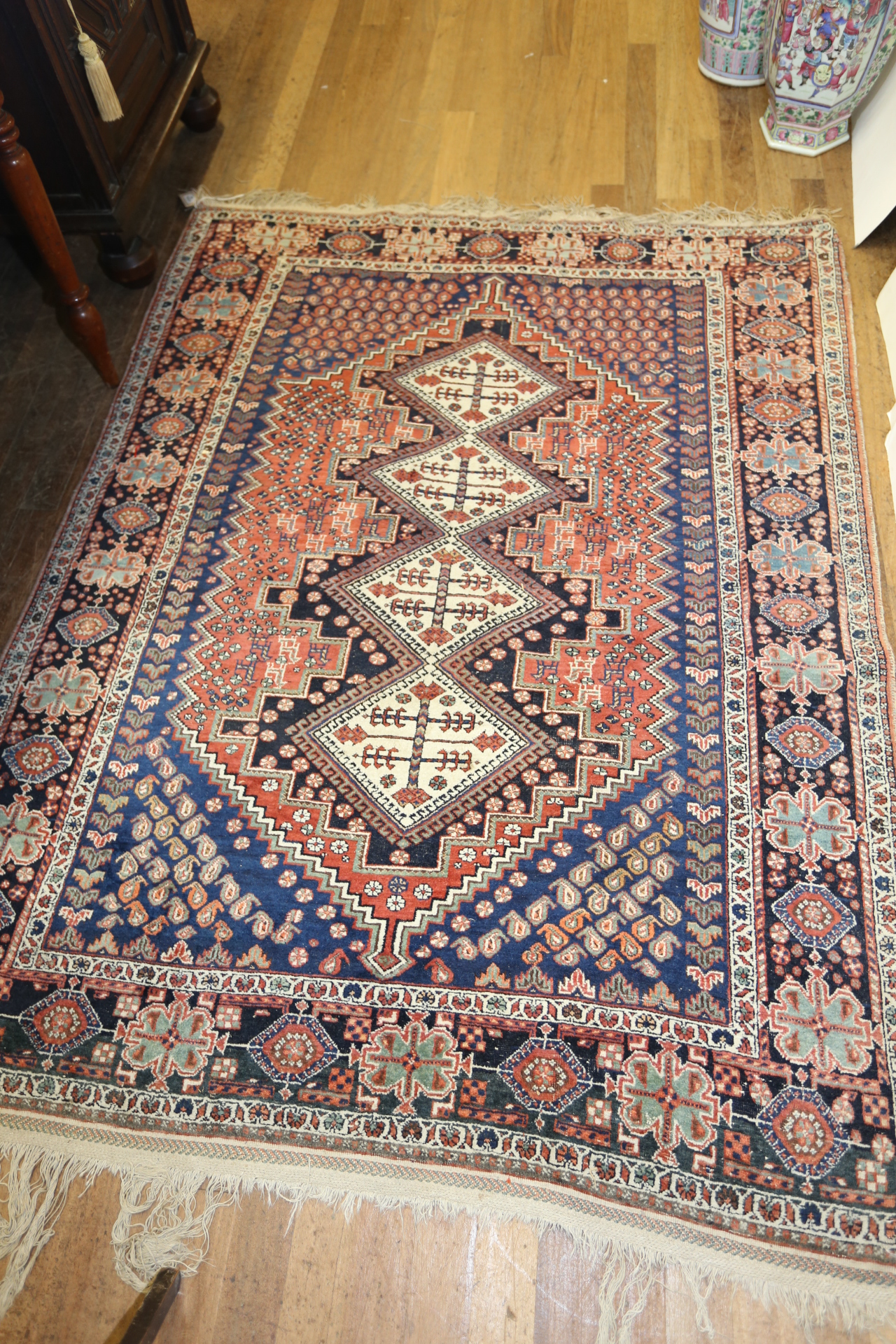 A 20TH CENTURY EASTERN BOKHARA RUG, central design of four lozenges with blue ground boteh leaf