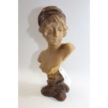 AN EDWARDIAN ART NOUVEAU INFLUENCE TERRACOTTA EFFECT PLASTER BUST OF A YOUNG MAIDEN, on an