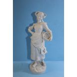 A 19TH CENTURY CONTINENTAL WHITE BISQUE PORCELAIN FIGURE OF A DUTCH GIRL with a wicker basket,