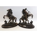 A PAIR OF EDWARDIAN BRONZE MARLY HORSES AND ATTENDANTS, after Coustou, raised on oval ebonised