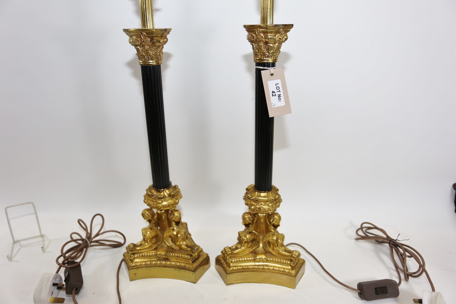 A PAIR OF GOOD QUALITY REPRODUCTION GILT BRASS AND BLACK TABLE LAMPS with corinthian capitals and