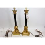 A PAIR OF GOOD QUALITY REPRODUCTION GILT BRASS AND BLACK TABLE LAMPS with corinthian capitals and