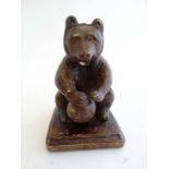 A mid 19thC German political stoneware pottery seated bear with a globe between his paws,