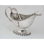 A silver plated sauce boat together with a silver plated 'fiddle pattern' sifting spoon (2)