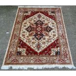 Carpet / Rug : A machine made Heriz carpet, the beige and red ground with stylised floral motiffs.