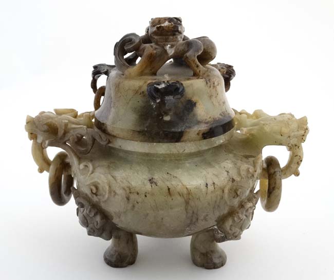 A Jade three footed censor with dragon mask handles and lid with further dragon decoration.