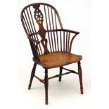 An 18thC / 19thC elm seated stick back armchair with wheel back splat 39 1/2" high