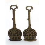 A pair of Georgian style cast brass and weighted iron door porters in the form of fruiting baskets