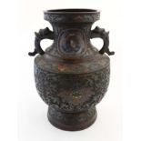 A large baluster shaped Oriental vase with cloisonne and cut decoration and twin carry handles.