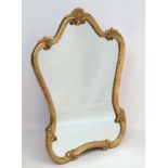 Mid Century / Hollywood Regency : a scallop shell bordered giltwood shaped wall mirror ,