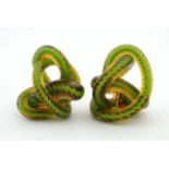 An unusual pair of 20thC glass paperweights formed as tapering glass twists of green and amber