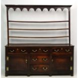 18 thC Oak Dresser : an open plate rack over a three top drawer and one over one central drawer