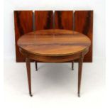 A 19thC Italian mahogany circular dining table extending via four leaves with four legs together