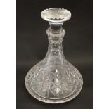 A cut glass ships decanter and stopper.