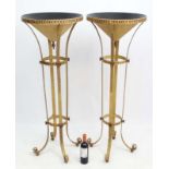 Mid Century / Hollywood Regency : a pair of floor standing torchieres with four feet and decorated
