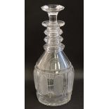 A cut glass three ring decanter with associated stopper.