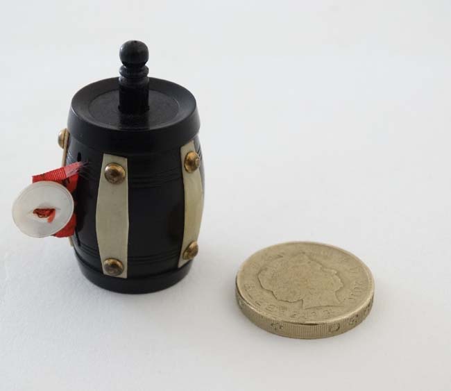 Sewing / Needlework : A tape measure formed as an ebonised barrel with ivorine banding held by - Image 2 of 4