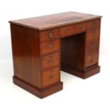 A late 19thC mahogany pedestal desk with gold tooled red leather insert to top 42" wide x 22" deep