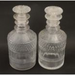 A pair of short cut glass decanters and stoppers.