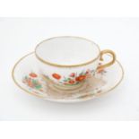 An early 19thC Chamberlain Worcester porcelain cup and saucer painted with calendula with scrolled