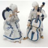 A pair of continental porcelain Dresden style figures in period dress, seated,