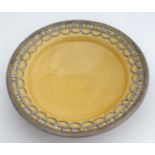 A sunset yellow dish , having applied decorative metal to rim. 10 1/2'' diameter.